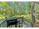 View of a back deck with grill and view of forest at 113 Fowler Dr, Bowdon, GA 30108
