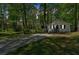 Exterior of house with driveway and front porch surrounded by a wooded landscape at 113 Fowler Dr, Bowdon, GA 30108