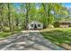 A home exterior is showcased with a lengthy driveway, green trees, and well manicured lawn at 113 Fowler Dr, Bowdon, GA 30108