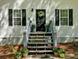 Up close exterior view of the front door, black shutters, plants, and wooden stairs at 113 Fowler Dr, Bowdon, GA 30108
