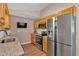 Open kitchen featuring stainless steel appliances, wooden cabinets, granite counters, and a mounted television at 113 Fowler Dr, Bowdon, GA 30108