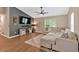 A cozy living room has a large sectional sofa, vaulted ceiling, ceiling fan, and a fireplace at 113 Fowler Dr, Bowdon, GA 30108