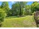 Expansive grassy backyard with mature trees offering shade and privacy for outdoor activities at 135 Longview Rd, Fayetteville, GA 30214