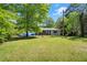 Nice lawn with trees surrounding the home with black shutters at 135 Longview Rd, Fayetteville, GA 30214