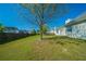 Spacious backyard with a mature tree, wooden fence, and partial view of the home's exterior at 1401 Kala Dr, Lithonia, GA 30058