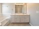 Bright bathroom featuring a double sink vanity with neutral wall and floor tiles at 1401 Kala Dr, Lithonia, GA 30058
