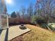 Fenced backyard featuring a concrete patio with a stone fire pit and a grassy area at 3723 Verde Glen Ln, Cumming, GA 30040