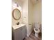 Cozy bathroom featuring vanity with sink, oval mirror, and toilet, creating a functional space at 3723 Verde Glen Ln, Cumming, GA 30040