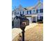 View of townhouse featuring a mailbox in front of a home with a two-car garage at 3723 Verde Glen Ln, Cumming, GA 30040