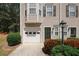Close-up view of townhome with a one-car garage, front door, and manicured landscaping at 4486 Thorngate Ln, Acworth, GA 30101