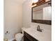 Well-lit half bathroom with decorative mirror, classic fixtures, and a wood-finish vanity offer both comfort and style at 4486 Thorngate Ln, Acworth, GA 30101