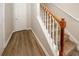 Interior shot of a carpeted staircase with wooden banister and a white door at 4486 Thorngate Ln, Acworth, GA 30101
