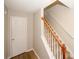 Interior shot of a carpeted staircase with wooden banister and a white door at 4486 Thorngate Ln, Acworth, GA 30101