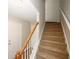 Carpeted staircase with wooden banister and a white door at 4486 Thorngate Ln, Acworth, GA 30101