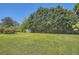 Wide shot of backyard with mature trees, a large grassy area, and small outbuilding at 6125 Dunbritan Ln, Atlanta, GA 30349