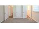 This is a spacious bedroom featuring neutral carpet and doors to closets and other rooms at 7268 Westwood Ln, Douglasville, GA 30134