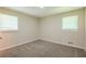 Neutral-toned bedroom with plush carpet and two windows, offering ample natural light at 7268 Westwood Ln, Douglasville, GA 30134