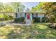 Charming ranch-style home with a red front door, carport, and well-maintained landscaping at 7268 Westwood Ln, Douglasville, GA 30134