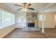 Sunlit living space showcasing a stone fireplace, built-in shelving, and stylish flooring at 7268 Westwood Ln, Douglasville, GA 30134