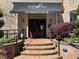 Inviting entrance to Serrano building with brick steps and manicured landscaping at 901 Abernathy Ne Rd # 5050, Atlanta, GA 30328