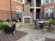 Relaxing brick-paved patio area with an outdoor fireplace, potted plants, and comfortable seating at 901 Abernathy Ne Rd # 5050, Atlanta, GA 30328