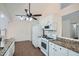 Eat-in kitchen features white cabinets, granite countertops, and wood-look tile flooring at 2939 Owens Point Nw Trl, Kennesaw, GA 30152