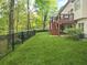 Expansive backyard with manicured lawn, iron fence and a two-story deck with stairs to the stone patio below at 315 Mossy Pointe, Duluth, GA 30097