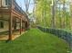 Beautiful backyard with a covered stone patio, iron fence, lush lawn and a view of mature trees at 315 Mossy Pointe, Duluth, GA 30097