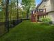 Expansive backyard with manicured lawn, iron fence and a two-story deck with stairs to the stone patio below at 315 Mossy Pointe, Duluth, GA 30097