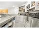 Bar area featuring counter seating, shelves of liquor, granite counter tops, and stainless steel sink at 315 Mossy Pointe, Duluth, GA 30097