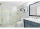 Bathroom featuring a glass shower, marble counter tops and walls, modern fixtures, and a stylish blue vanity at 315 Mossy Pointe, Duluth, GA 30097