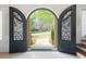 The home features a stunning arched entry door with a view of the landscaped front yard and home at 315 Mossy Pointe, Duluth, GA 30097
