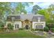 Stately home with manicured lawn, lush landscaping, and charming architectural details at 315 Mossy Pointe, Duluth, GA 30097