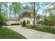 Elegant exterior of home with a circular drive, beautiful landscaping, and manicured greenery at 315 Mossy Pointe, Duluth, GA 30097