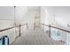 Upstairs hallway with carpet, white railings, wooden posts, and decorative lighting at 315 Mossy Pointe, Duluth, GA 30097