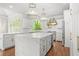Elegant kitchen boasts marble counters, an island, stainless steel appliances, and stylish lighting at 315 Mossy Pointe, Duluth, GA 30097