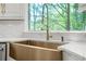 Kitchen boasts a gold farmhouse sink and a view of the tree lined property at 315 Mossy Pointe, Duluth, GA 30097