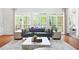 Bright living room featuring hardwood floors, walls of windows, and charming design at 315 Mossy Pointe, Duluth, GA 30097