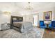 Luxurious main bedroom with elegant chandelier lighting and two plush blue accent chairs at 315 Mossy Pointe, Duluth, GA 30097