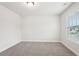This bedroom features neutral paint, carpet, a single window and base trim at 4785 Marjorie Dr, Cumming, GA 30041