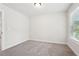 This bedroom features neutral paint, carpet, a single window and base trim at 4785 Marjorie Dr, Cumming, GA 30041