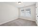This bedroom features neutral paint, carpet, a single window and base trim at 4785 Marjorie Dr, Cumming, GA 30041