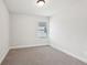 This bedroom features neutral paint, carpet, a single window and base trim at 4785 Marjorie Dr, Cumming, GA 30041