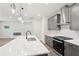 Kitchen island with gray cabinets, quartz countertop, and stainless steel appliances, flowing into the living room at 4785 Marjorie Dr, Cumming, GA 30041