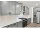 This kitchen features gray cabinets, a stainless steel refrigerator, quartz countertops, and stainless steel appliances at 4785 Marjorie Dr, Cumming, GA 30041