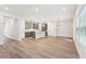 Open-concept living space featuring hardwood floors, gray cabinets, and plenty of natural light from the windows at 4785 Marjorie Dr, Cumming, GA 30041