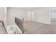 This loft area features neutral carpet, stair railings, and natural light from the windows at 4785 Marjorie Dr, Cumming, GA 30041