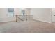 This loft area features neutral carpet, stair railings with black metal balusters, and natural light from the windows at 4785 Marjorie Dr, Cumming, GA 30041