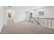 This loft area features neutral carpet, a view of two hallways, stair railings, and natural light from the windows at 4785 Marjorie Dr, Cumming, GA 30041
