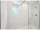 Modern shower with seamless glass door, shower head, seat, and sleek white tiling at 4785 Marjorie Dr, Cumming, GA 30041